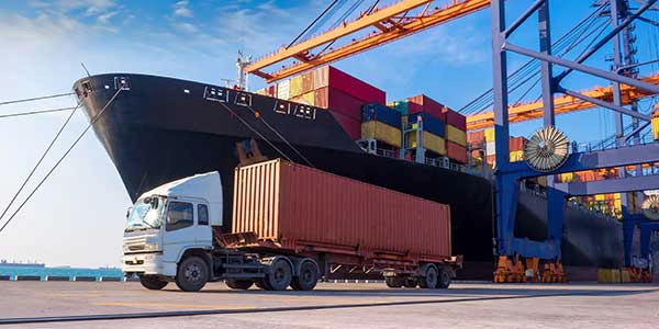 a truck with a ship in a port